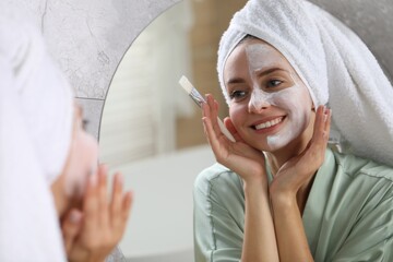 Woman with face mask in front of mirror indoors. Spa treatments