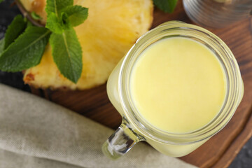 Tasty pineapple smoothie on table, closeup. Top view