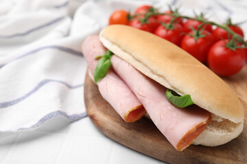 Delicious sandwich with ham and basil on white table, closeup. Space for text