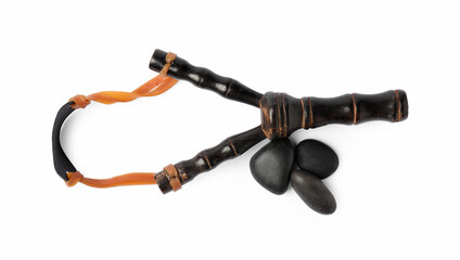Black wooden slingshot with stones on white background, top view