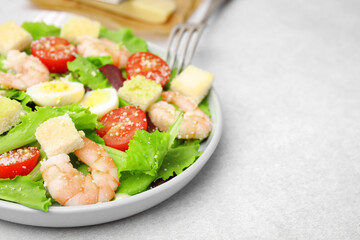 Delicious Caesar salad with shrimps on light table, closeup. Space for text