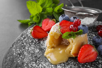 Tasty vanilla fondant with white chocolate and berries on grey table, closeup. Space for text