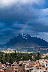 Fototapeta na wymiar Magnificent rainbow over the mountain peaks covered with snow at sunset in the Peruvian city of Huaraz.
