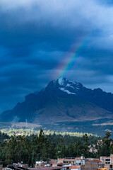 Magnificent rainbow over the mountain peaks covered with snow at sunset in the Peruvian city of Huaraz.