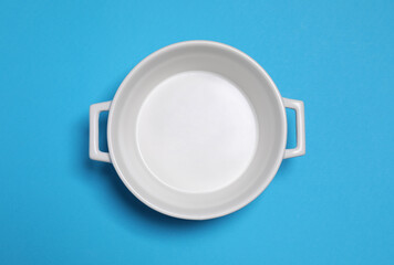 White empty pot on light blue background, top view