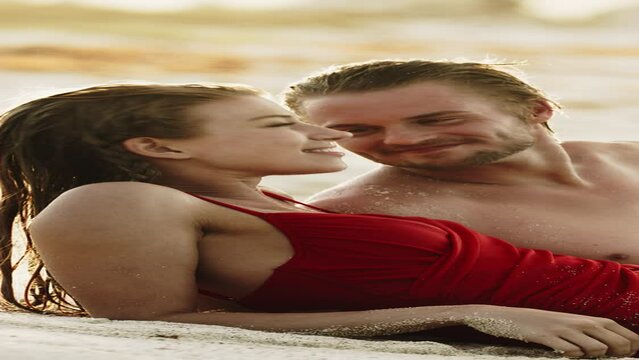 Romantic couple laying on beach talking and kissing  - vertical video / Petit Tabac, Tobago Cays, St. Vincent and the Grenadines