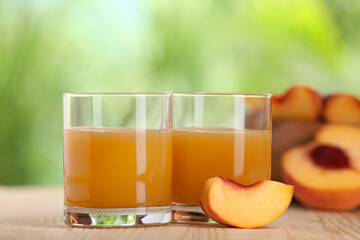 Tasty peach juice and fresh fruits on wooden table outdoors, closeup