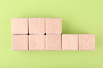International Organization for Standardization. Wooden cubes with abbreviation ISO and number 22000 on light green background, flat lay