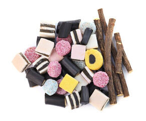 Many tasty candies and dried sticks of liquorice root isolated on white, top view