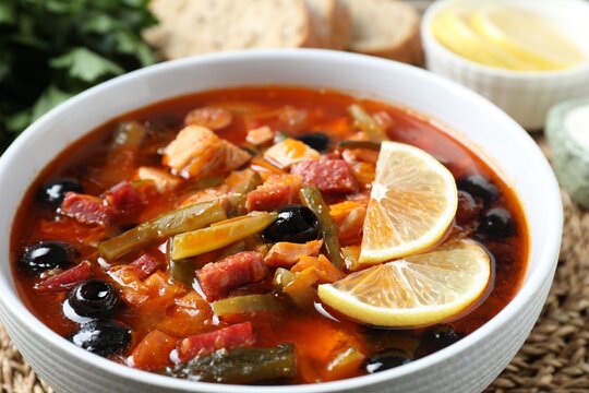 Meat solyanka soup with sausages, olives and vegetables on table, closeup