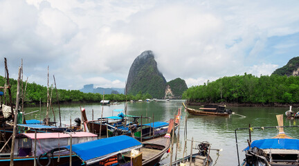 Cloudy morning at Fishing villages with long tail boat ,mangrove forest and island
