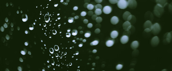Atmospheric minimal monochrome backdrop with rain droplets on glass. Wet window with rainy drops...