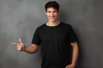 advertising copyspace shirt t black finger index pointing while smiling wall textured gray isolated man young point template t-shirt model male background casual attire blank guy mock fashion - obrazy, fototapety, plakaty