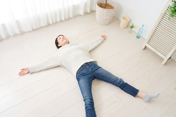 床暖房イメージ　フローリングに寝転ぶ女性