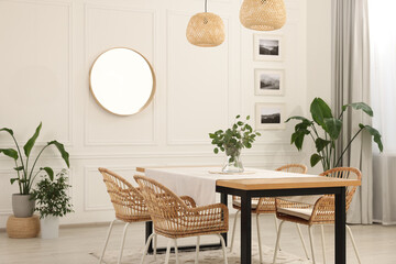 Stylish dining room with cozy furniture, mirror and plants