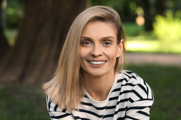 Portrait of happy woman in casual clothes outdoors. Attractive lady smiling and looking into camera