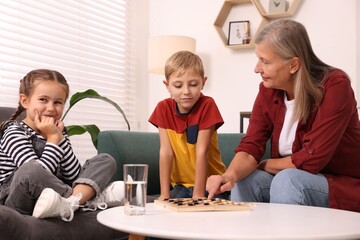 Family playing checkers at coffee table in room