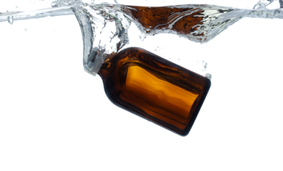 Amber glass bottle Cosmetic container fall into clear water with air bubble. Cosmetic treatment container drop to clear water of freshness. White background isolated freeze element