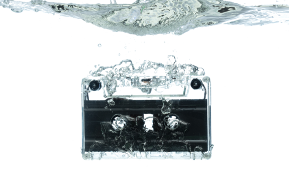 Cassette retro vintage Tape fall into clear water with air bubble. Black retro vintage cassette magnetic tape drop to wash old time. White background isolated freeze element