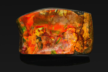a rock mineral of opalescent color on a black background