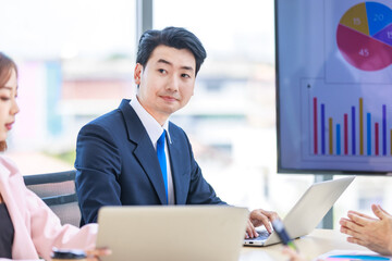 Asian professional successful male and female businessman businesswoman partnership colleagues in formal business suit sitting  listening in meeting room in company office.