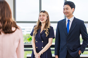 Millennial Asian professional successful young male female businessman businesswoman management with secretary in formal business suit outfit standing smiling discussing with customer in meeting room