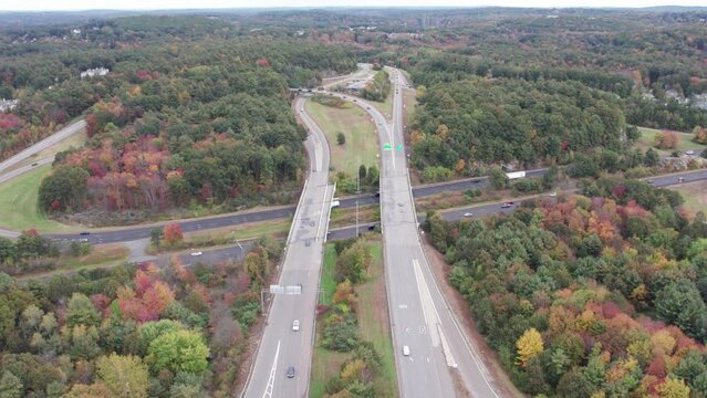Drone footage over Donald Lynch Boulevard and Route 495 in Marlboro, Massachusetts. Traffic moving north and south, with fall foliage and residential areas surrounding.