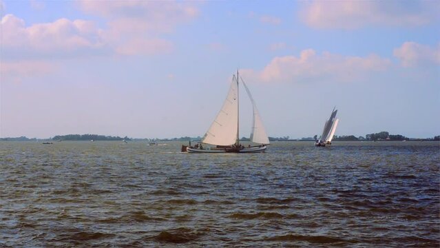 Traditional sailing boat making a turn around a buoy.