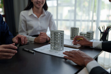 Young Asian architect colleagues discussing construction plans, blueprints and planning budgets Structural guidelines in the project at the construction site office technological concept.