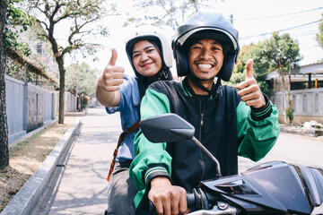 Young Asian commercial online taxi driver and female passenger showing thumbs up to camera - obrazy, fototapety, plakaty