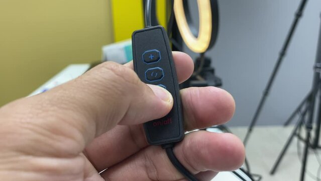 Male finger clicking on lamp switch. Increase, decrease , change  light colour of lamp indoor studio office. Turn on and turn off light.
