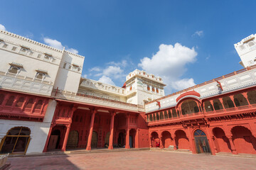 Fototapeta premium Buildings with red and white facades under blue sky and white clouds. Junagarh Fort is located in Bikaner, Rajasthan, India