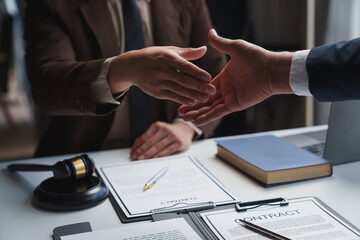 Lawyers shake hands with business people to seal a deal with partner lawyers or a lawyer discussing contract agreements, handshake concepts, agreements. - obrazy, fototapety, plakaty