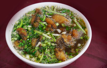 Fried fish noodles garnished with green onions and celery