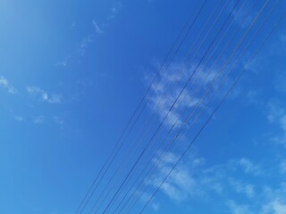 Power transmission lines against deep blue sky with copy space
