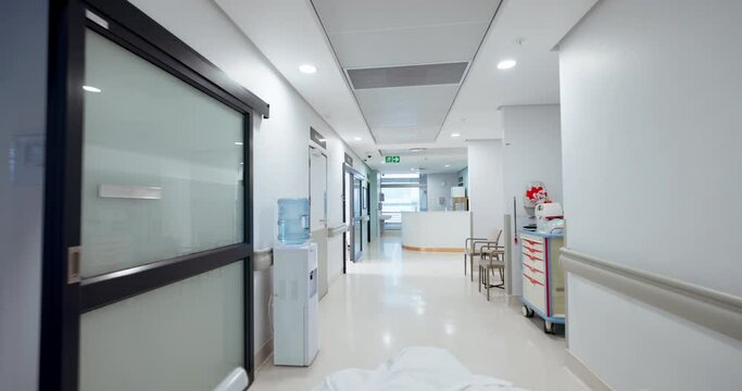 Hospital, empty hallway and gurney pov or medicare at clinic, medical and care in corridor. Medicine, wellness and treatment for illness, support and trust in emergency, lobby and service for injury