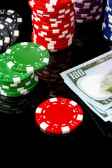 Poker chips and dollar bills on black background studio shot