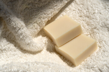 two bars of soap lie on a towel