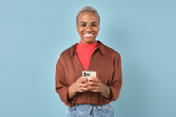 Young happy casual African American woman with smile holding smartphone and looking at camera after...