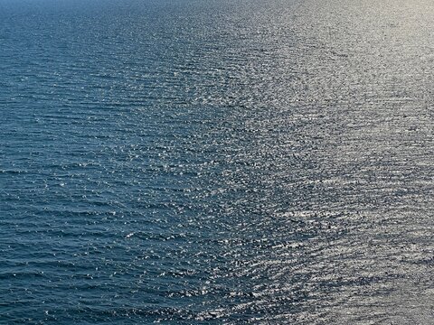 Sea water blue silver glittering surface.