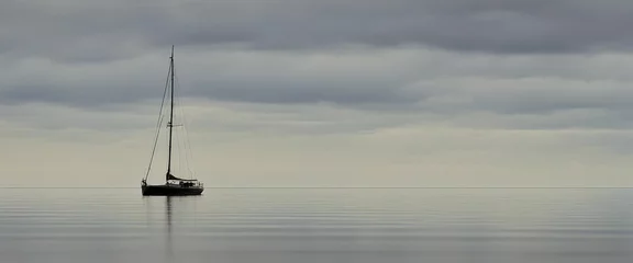 Foto op Canvas sail boat on a calm sea © Crimz0n