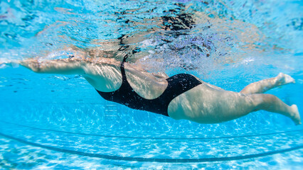 Girl Female Athlete Swimming Motion Active Close Up Underwater Side On in Black Full Piece Costume.
