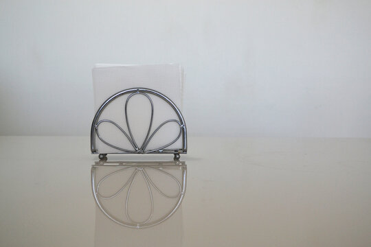 A Napkin Holder On A Table With A White Background