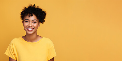 Obraz na płótnie Canvas Smimilg young woman with dark skin and short groomed hair isolated on flat yellow pastel background with copy space. Model for banner of cosmetic products, beauty salon and dentistry