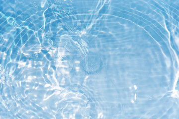 Defocus blurred transparent blue colored clear calm water surface texture with splashes reflection. Trendy abstract nature background. Water waves in sunlight with copy space. Blue watercolor shine.