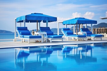 Fototapeta premium stacked blue pool loungers beside the clear pool