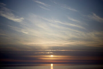 Obraz premium Amazing scenery with sky coloured by the sunset reflecting the calm sea water, selective focus