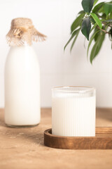 Milk in a glass, bottle of milk, light stylish kitchen