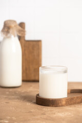 Milk in a glass, bottle of milk, light stylish kitchen