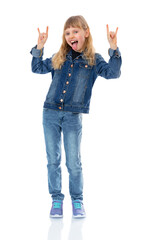 Full-length portrait of ten year old kid showing rock gesture with hands, shows her tongue and looking to the camera, isolated on white background. Blondy girl smiling and posing in studio.